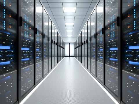 Lang gang i et datacenter med serverracks på begge sider og oplyst loft