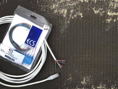 Installatørprodukter af mærket ECS vist sammen: patchkabel, skruetrækker og installationsboks.