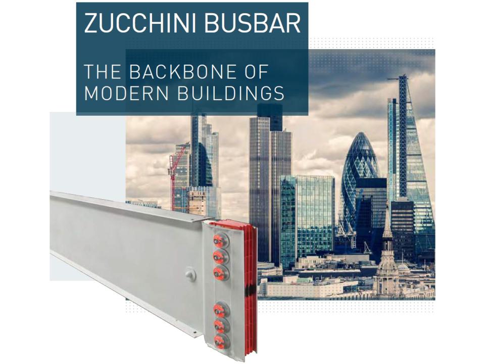 Reklamebillede for Zucchini Busbar med teksten 'The Backbone of Modern Buildings'. Til venstre ses en busbar-strømskinne fra Zucchini, og i baggrunden ses en skyline med moderne højhuse og skyskrabere.