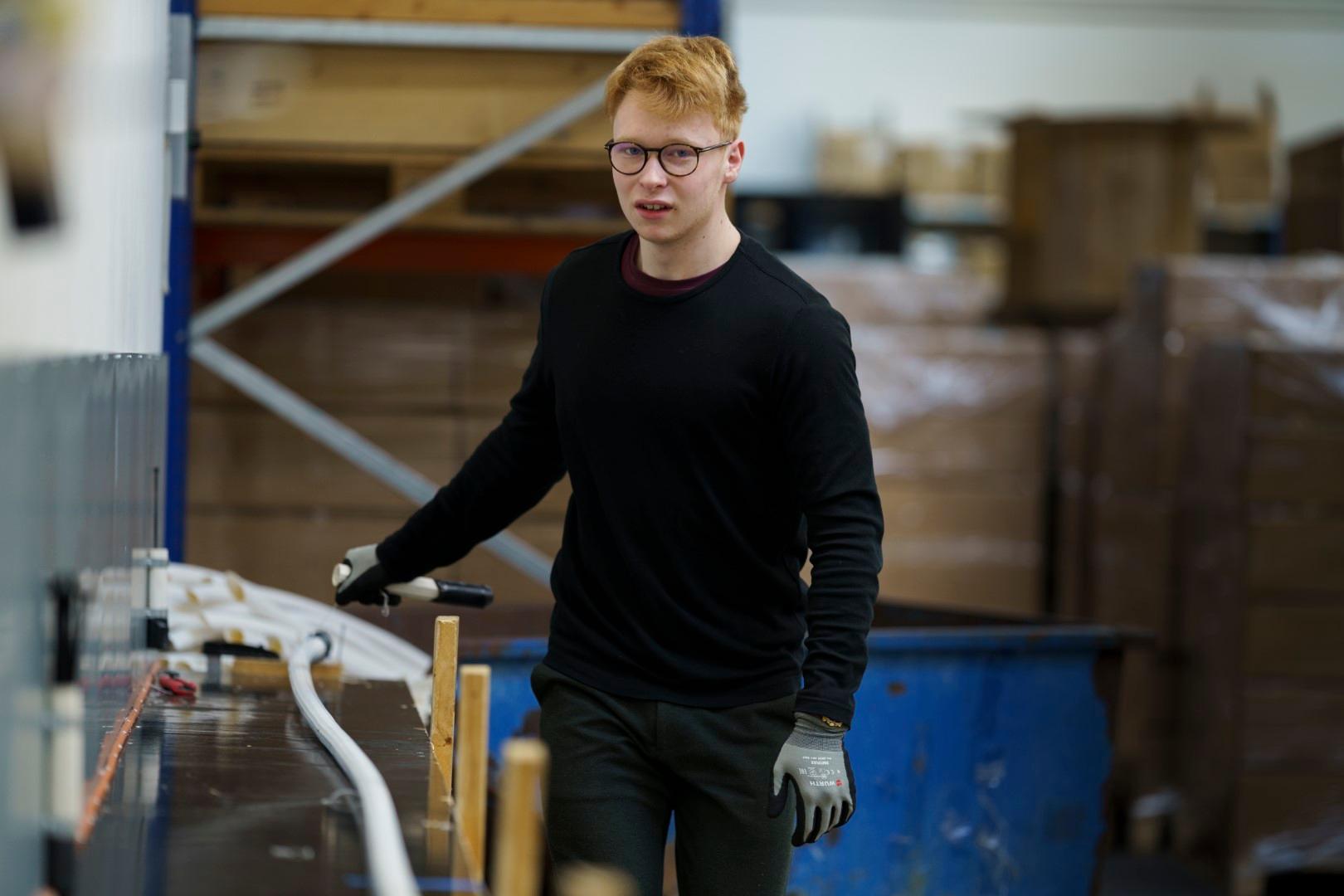 medarbejder i Alcadons produktionsafdeling bearbejder fiberrør